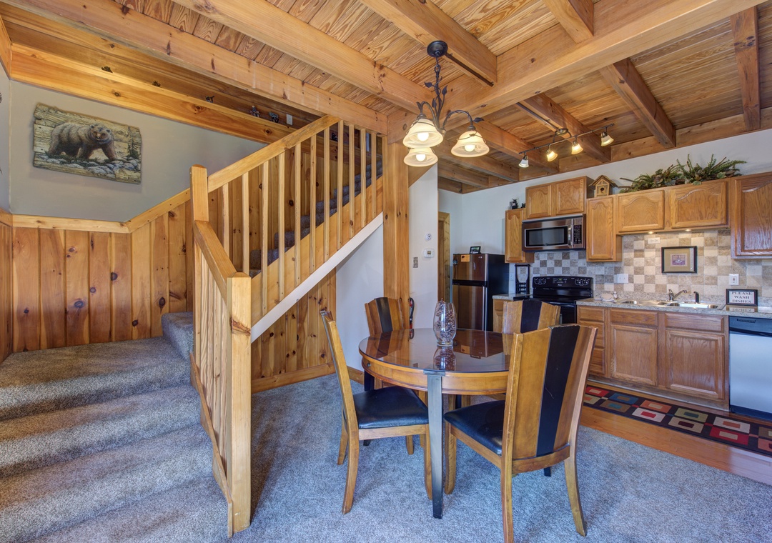 Warm wood beams frame your cozy dining space, where you'll gather for meals beneath rustic charm and mountain-inspired decor.