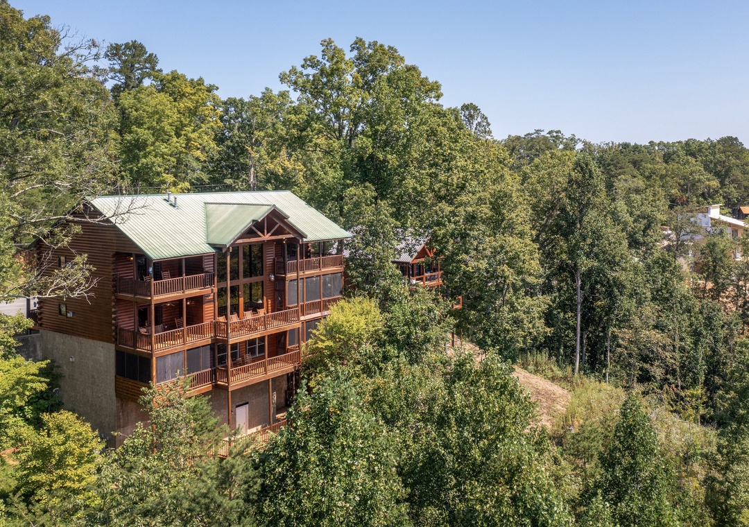 Secluded mountain cabin nestled in lush forest, featuring multi-level balconies and stunning natural surroundings for a peaceful retreat.