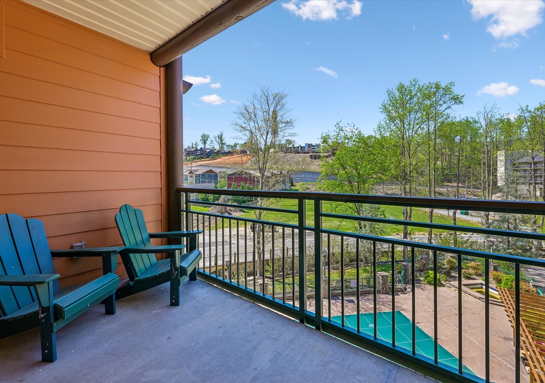 Relax in colorful Adirondack chairs on your private balcony overlooking lush trees and peaceful neighborhood views.