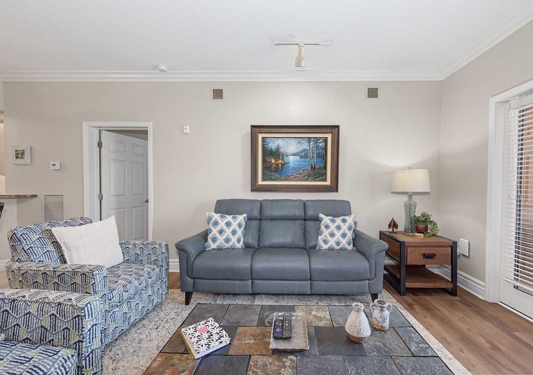 Sink into plush seating in your bright living room, where lake artwork and patterned pillows create a peaceful retreat for relaxation.