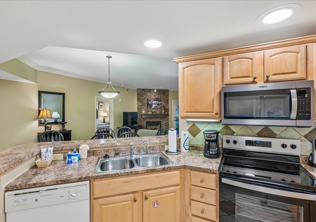 Your fully equipped kitchen features granite counters, modern appliances, and opens to the cozy living space with fireplace.
