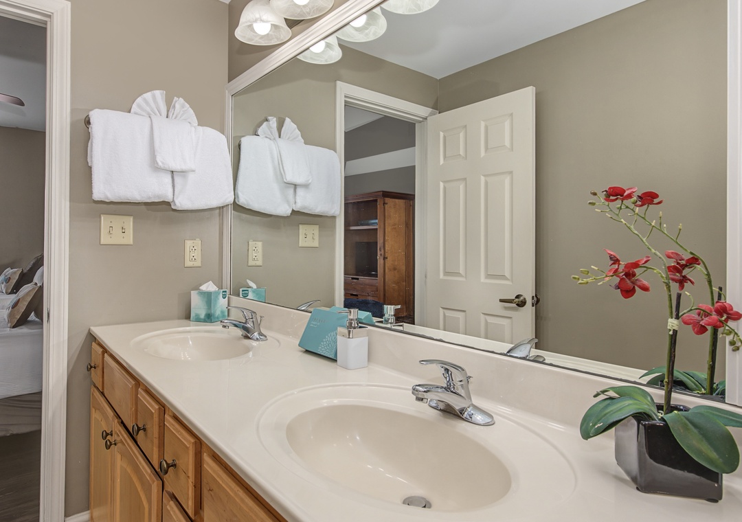 Step into your elegant ensuite bathroom, where fresh towels await and beautiful orchids add a welcoming touch to your daily routine.