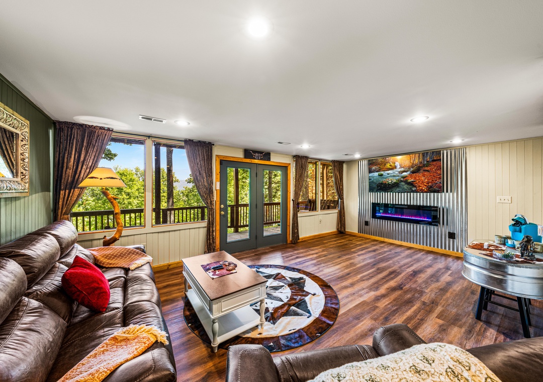 Sink into plush leather seating as natural light floods through floor-to-ceiling windows framing lush forest views. Your private retreat features a modern fireplace and direct balcony access.