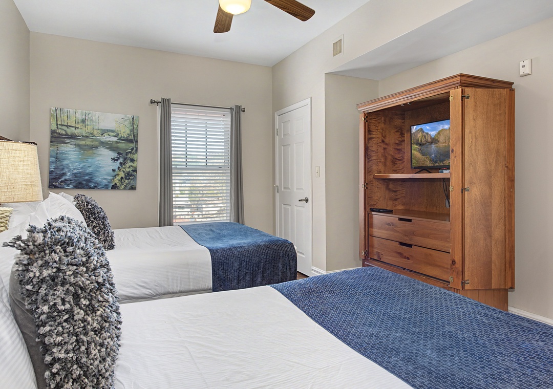 Rest peacefully in your bright, comfortable bedroom featuring two cozy beds, soothing decor, and charming exposed ceiling beams.