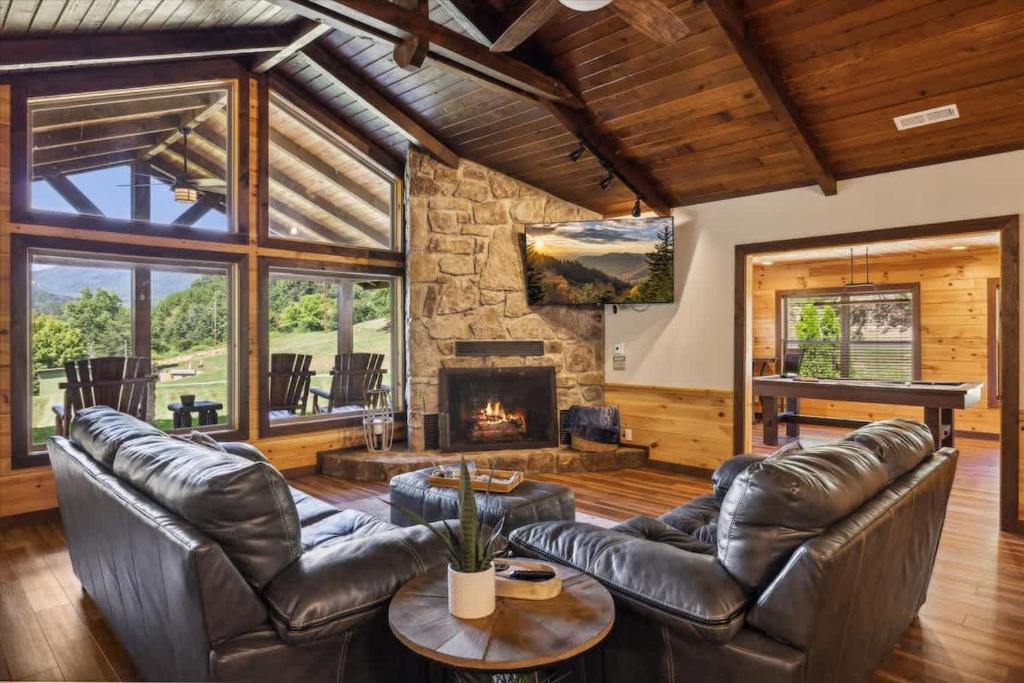 Unwind in your inviting living room with vaulted wood ceilings, a crackling stone fireplace, and floor-to-ceiling windows framing serene garden views—perfect for cozy evenings or relaxed afternoons.