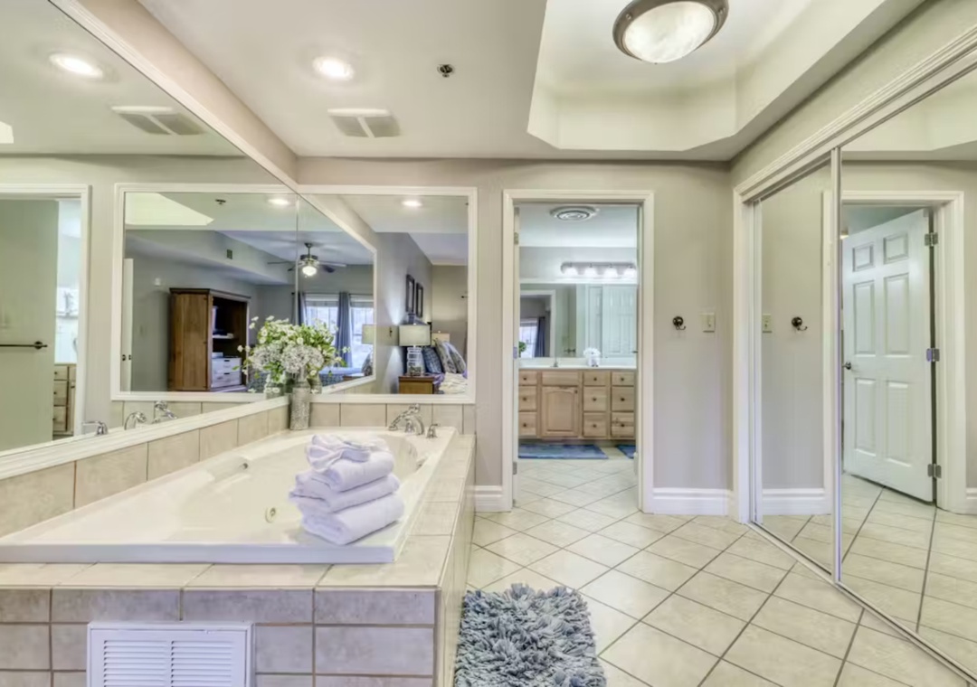 Sink into pure luxury in your spa-like master bathroom, featuring a soaking tub with plush towels and elegant mirrors.