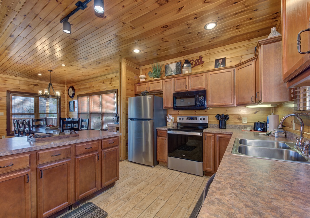 Your fully-equipped kitchen features granite countertops, stainless appliances, and warm wood cabinetry—perfect for preparing family meals or morning coffee before exploring the day's adventures.