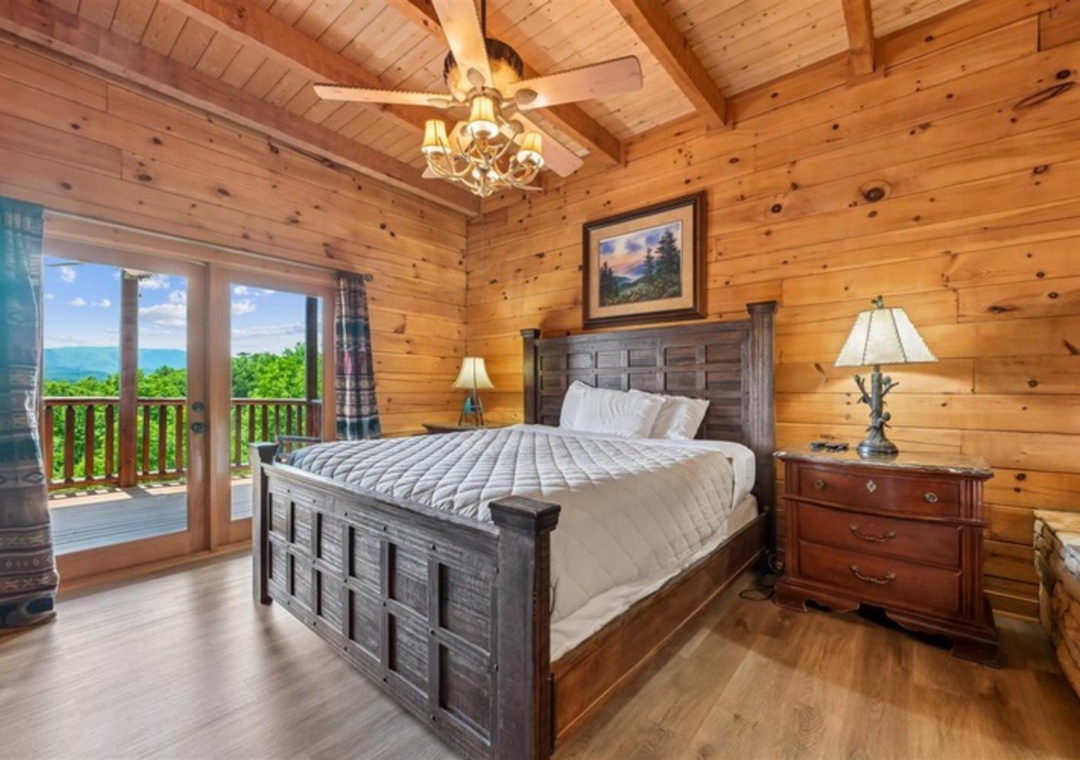 Wake up to stunning mountain views from your private balcony in this cozy cabin bedroom, where rustic wood beams and a plush king bed create the perfect retreat after a day of adventure.