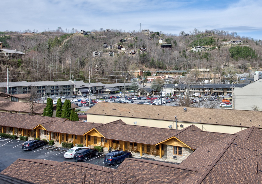 Aerial view of the property nestled in a scenic mountain valley with convenient parking and nearby town amenities.