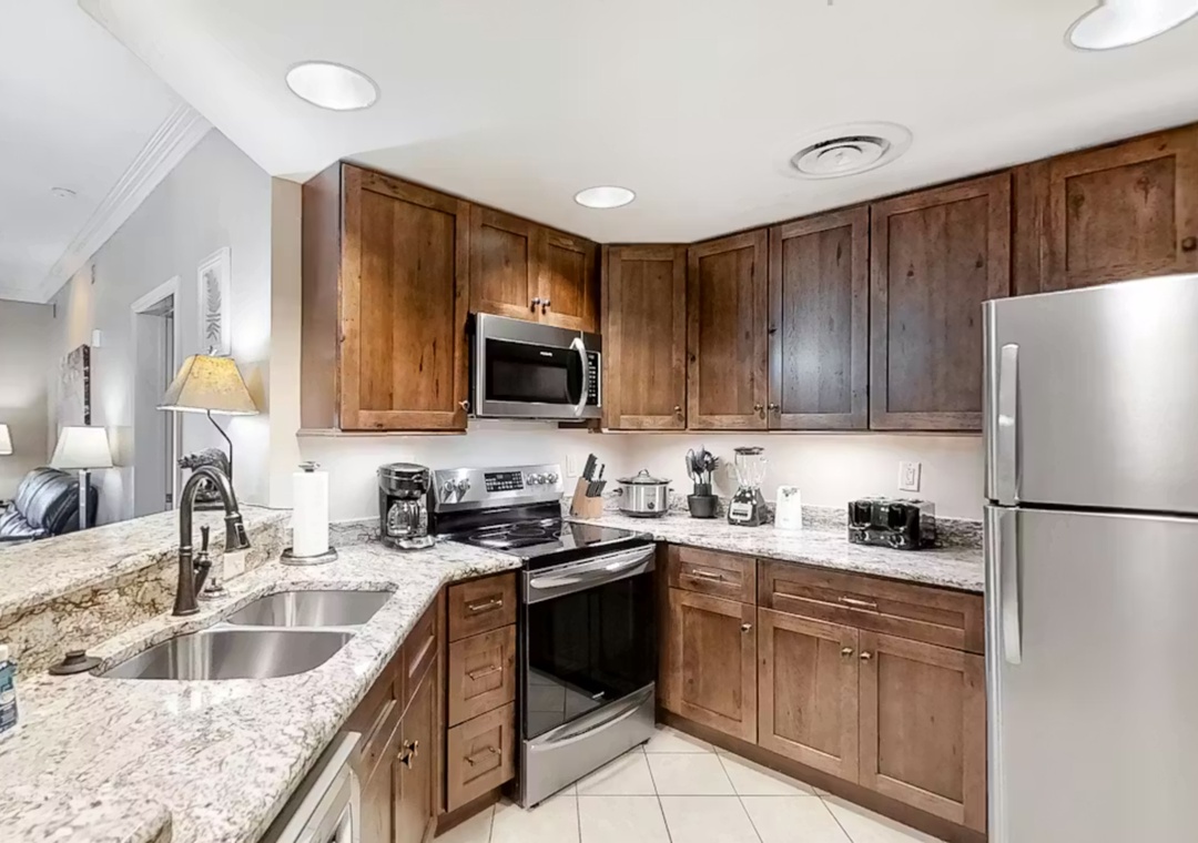 Your fully equipped kitchen features granite countertops, stainless steel appliances, and warm wood cabinets—perfect for preparing memorable meals during your stay.