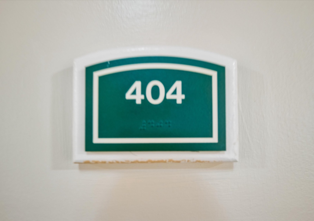 Room 404 awaits your arrival with a distinctive green nameplate marking your private accommodation.