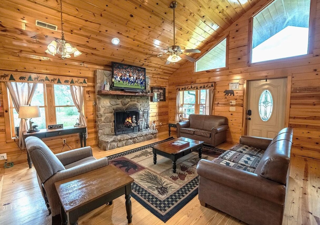 Gather around the stone fireplace in your cozy living room with vaulted ceilings, soft leather seating, and rustic charm framing every moment together.