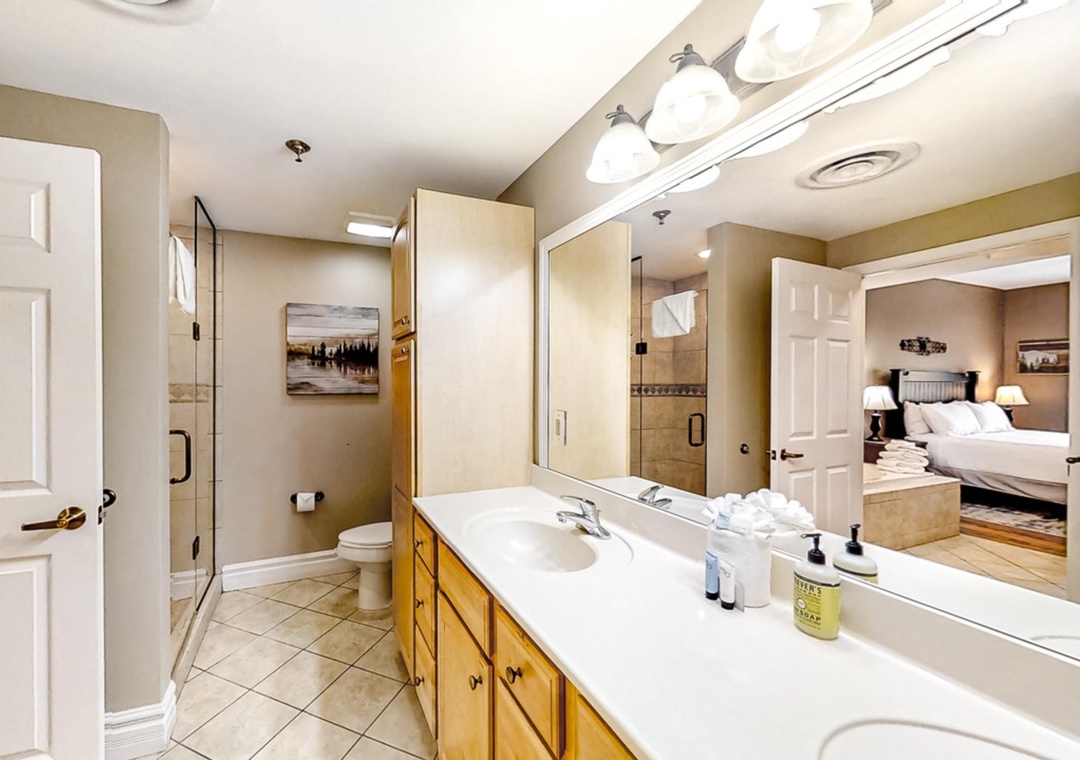 Your spacious ensuite bathroom features dual vanities, gleaming countertops, and premium toiletries for your comfort.