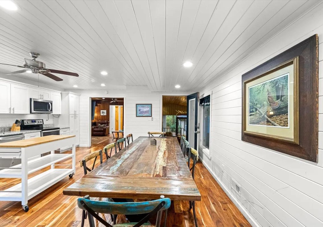 Gather around the rustic farmhouse table where mornings begin with coffee and laughter, and evenings linger over shared meals. The open layout connects you to the bright kitchen while natural light pours in from every angle.