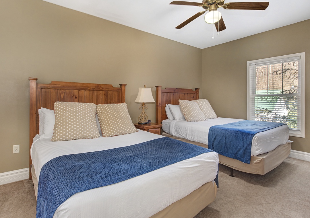 Two comfortable beds with crisp linens and charming blue accents await your restful stay in this peaceful bedroom.