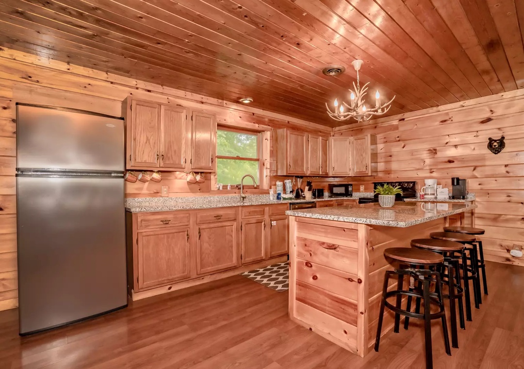 Your rustic cabin kitchen features rich wood throughout, granite countertops, and a welcoming island perfect for morning coffee or evening gatherings.