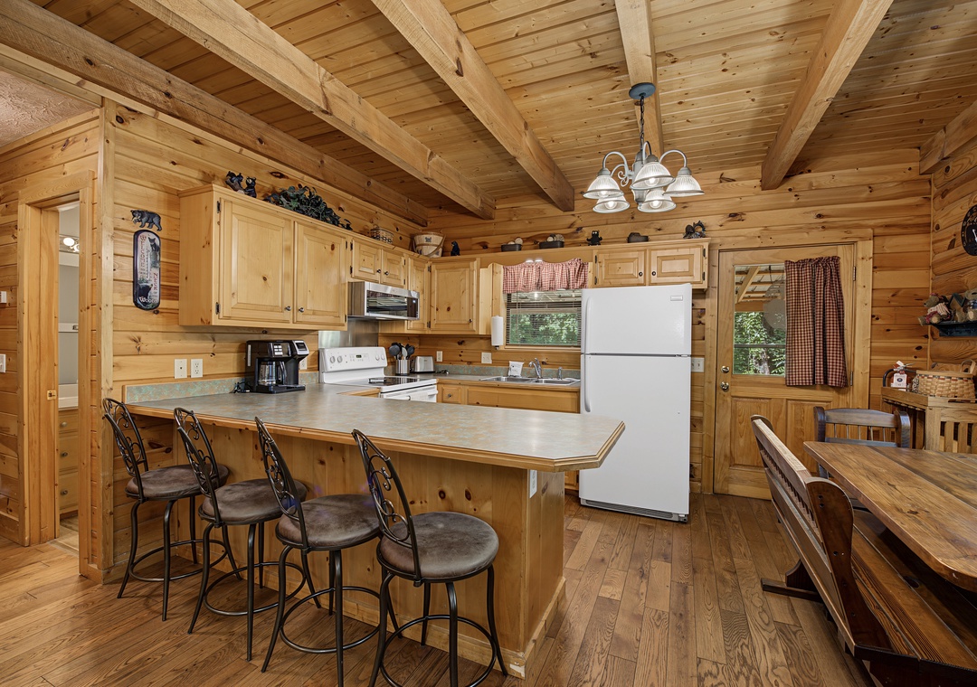 Gather around the rustic wooden island with comfortable seating, where you'll find everything you need to prepare delicious meals in this fully equipped cabin kitchen with modern appliances.