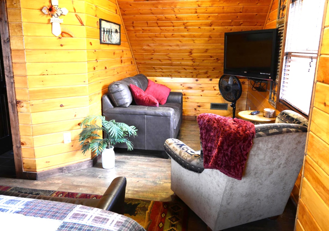 Cozy up in your rustic living space with warm wood walls, plush seating, and everything you need to unwind after your adventures.