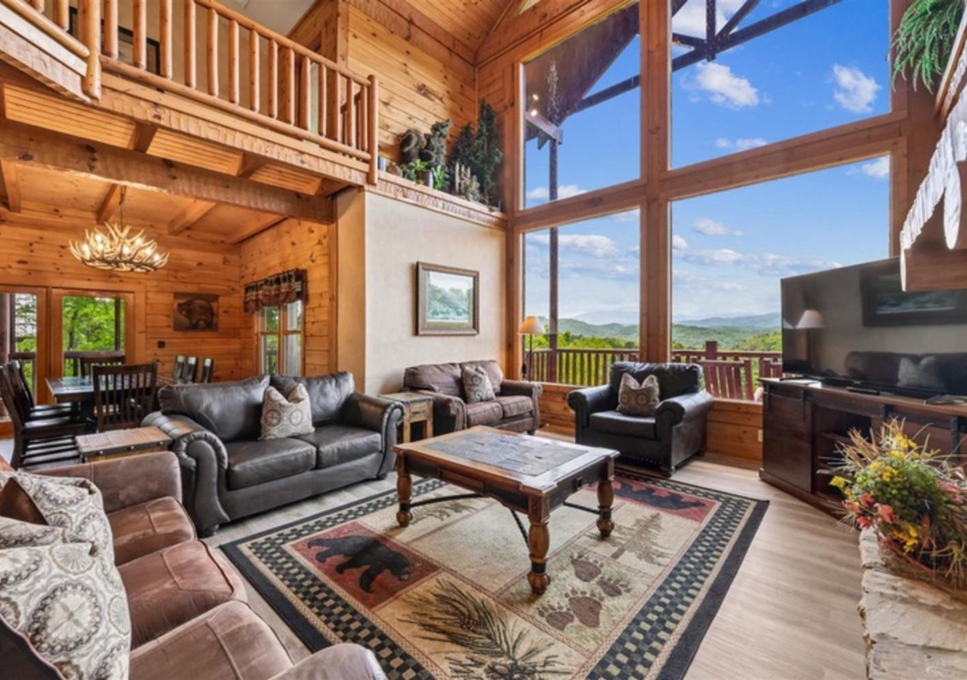 Sink into plush sofas as sunlight pours through towering windows, framing stunning mountain vistas. The rustic wood beams and cozy seating create your perfect retreat for relaxation.
