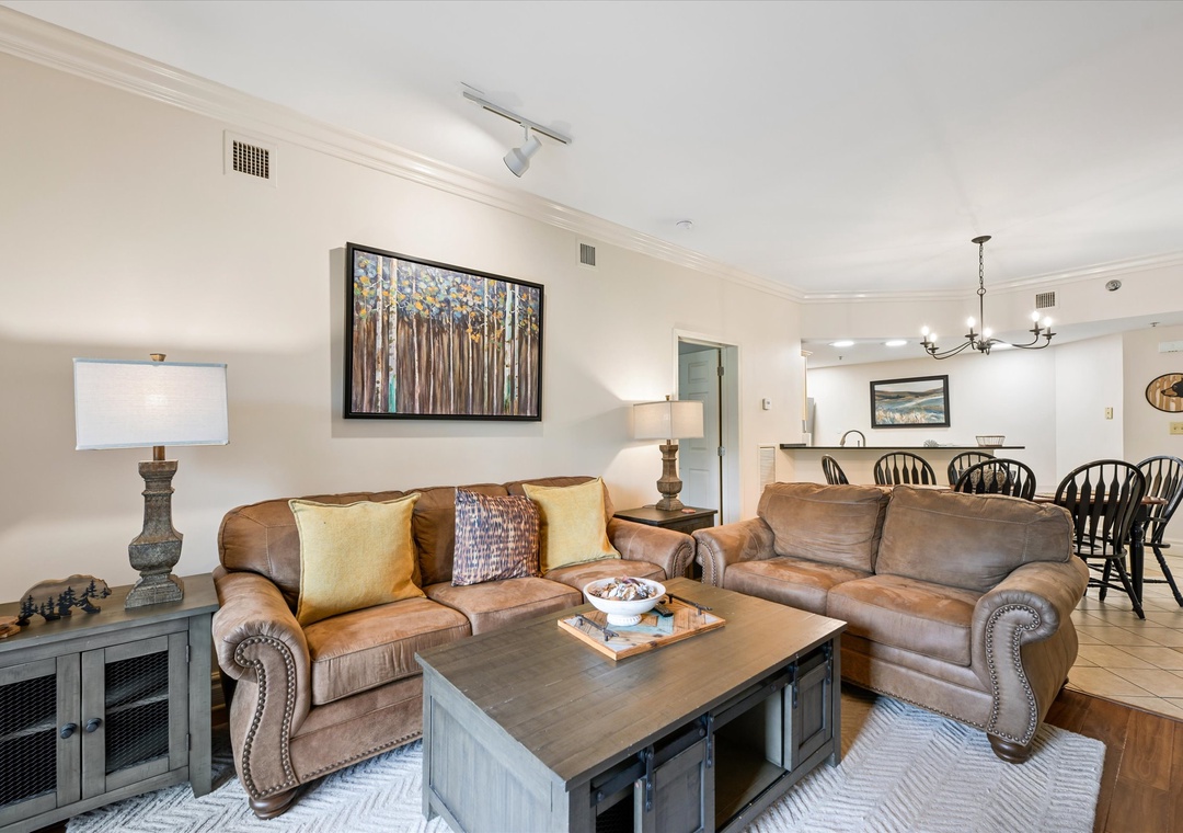 Sink into plush leather sofas in your spacious living area, where warm wood tones and thoughtful artwork create the perfect space for relaxation.