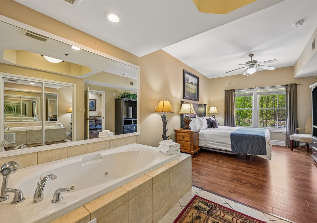 Unwind in your luxurious master suite featuring a romantic jetted tub, plush bedding, and warm wood floors for ultimate relaxation.