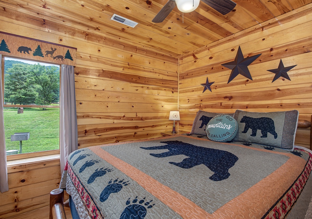 Cozy up in your rustic bedroom with warm wood walls and charming mountain-themed décor. Wake to peaceful garden views through your window.