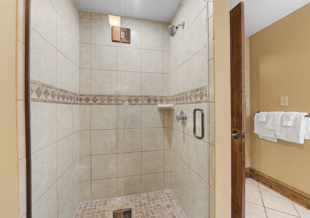 Step into your spacious walk-in shower with elegant tile work and premium fixtures for a truly refreshing experience.