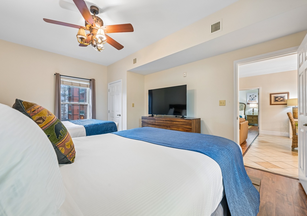 Rest peacefully in your spacious bedroom with twin beds, charming ceiling fan, and entertainment center for cozy evenings in.