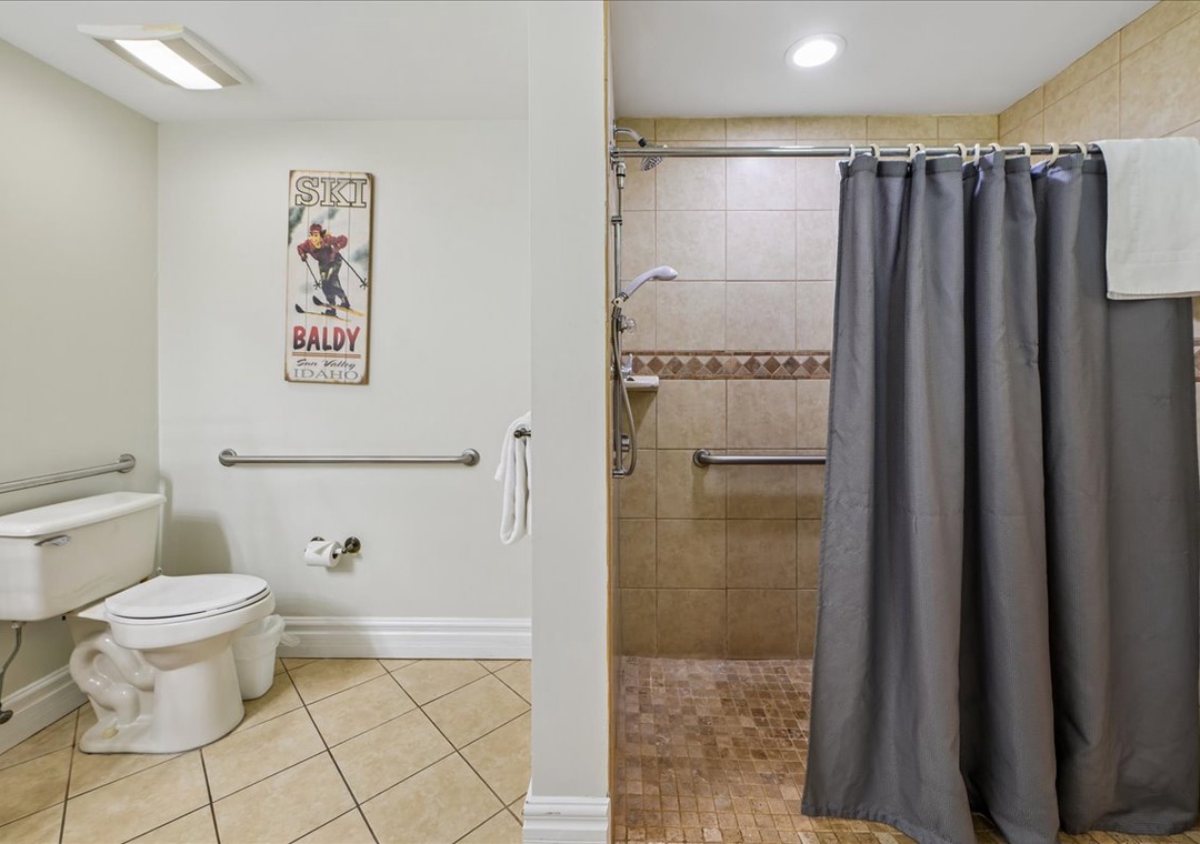 Step into your spacious bathroom with accessible shower, safety rails, and mountain-themed touches that make you feel right at home.