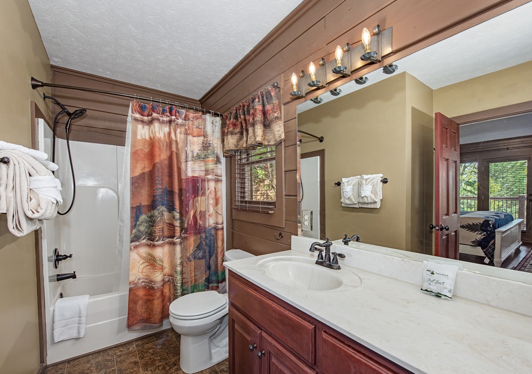 Your cozy bathroom features warm wood accents, soft lighting, and fresh towels for a comfortable mountain getaway.