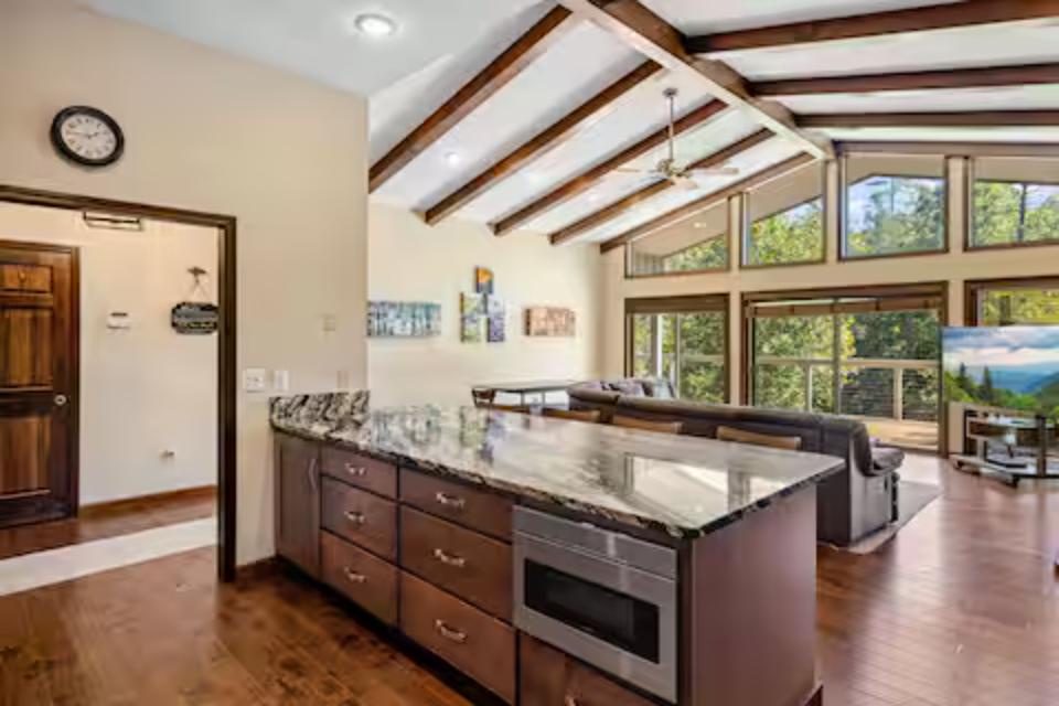 Cook with natural light streaming through soaring windows in your gourmet kitchen, complete with granite counters and rich wood finishes.