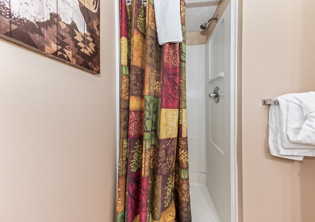 Step into your private spa-like shower with vibrant autumn-themed curtains and fluffy towels waiting for your relaxation.