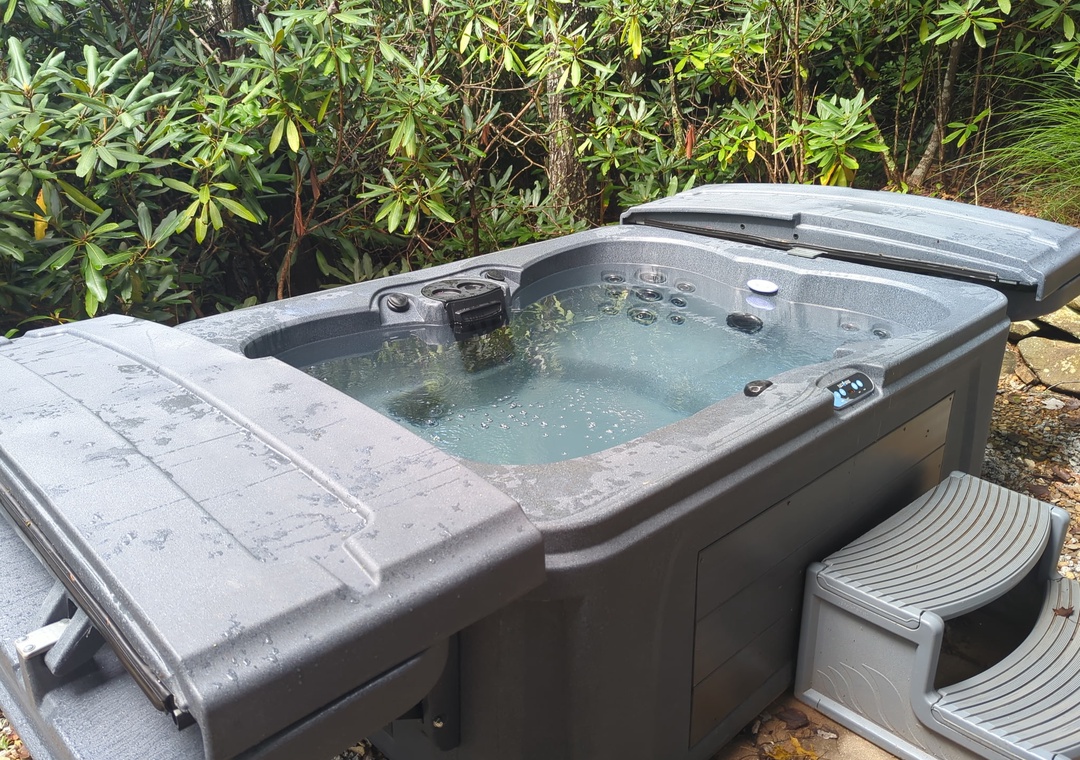 Picture yourself soaking away your cares in this private outdoor hot tub, surrounded by lush greenery and the sounds of nature. Pure relaxation awaits.