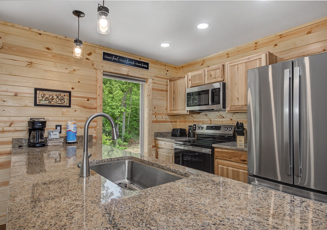 You'll love cooking in this bright, modern kitchen with granite counters, stainless appliances, and natural wood finishes that create a warm, inviting space for your mountain getaway.