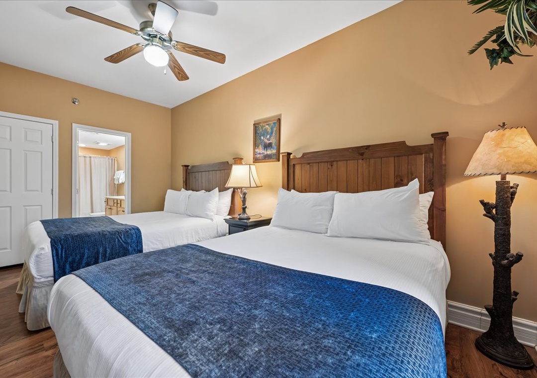 Drift into comfort in your spacious bedroom with twin beds, rustic wooden headboards, and ambient lighting that creates the perfect retreat.