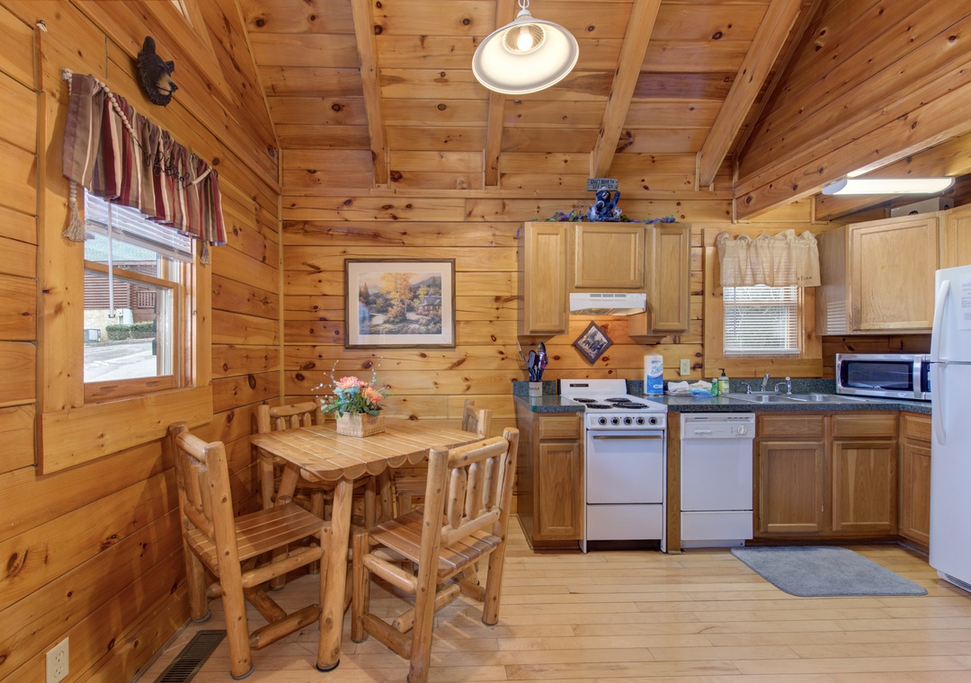Gather around your rustic log dining table in this cozy cabin kitchen, where wood beams frame memorable meals together.