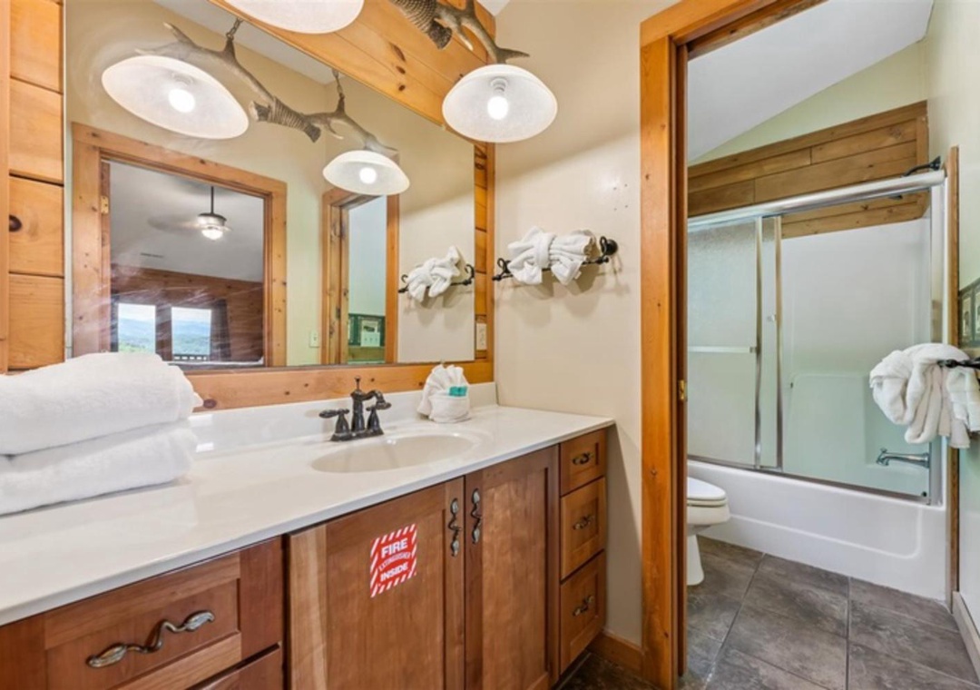 Refresh after your adventures with plush towels, a spacious vanity, and charming rustic wood accents. Your private bathroom awaits with modern fixtures and a soothing tub-shower combo.