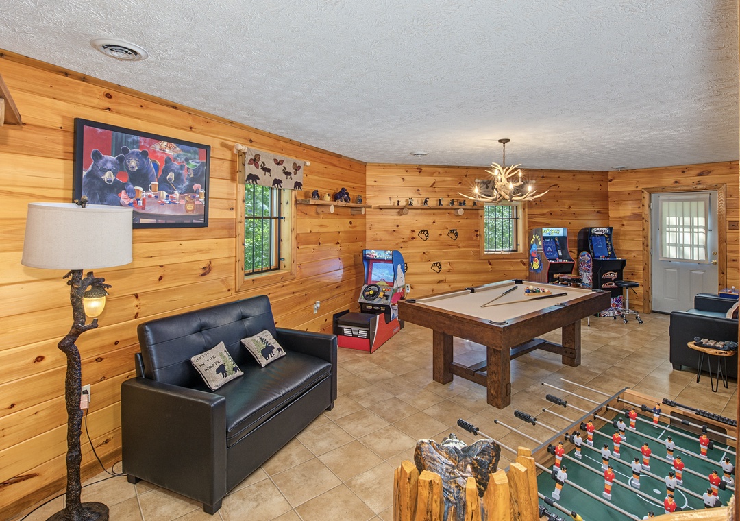 Game on in your private entertainment space! This rustic game room invites you to unwind with pool, foosball, and arcade classics—all yours to enjoy under the warm glow of the antler chandelier.