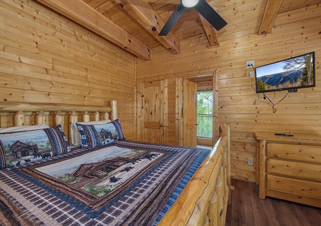 Your rustic bedroom features handcrafted log furniture and mountain views on the wall-mounted TV for cozy evenings.