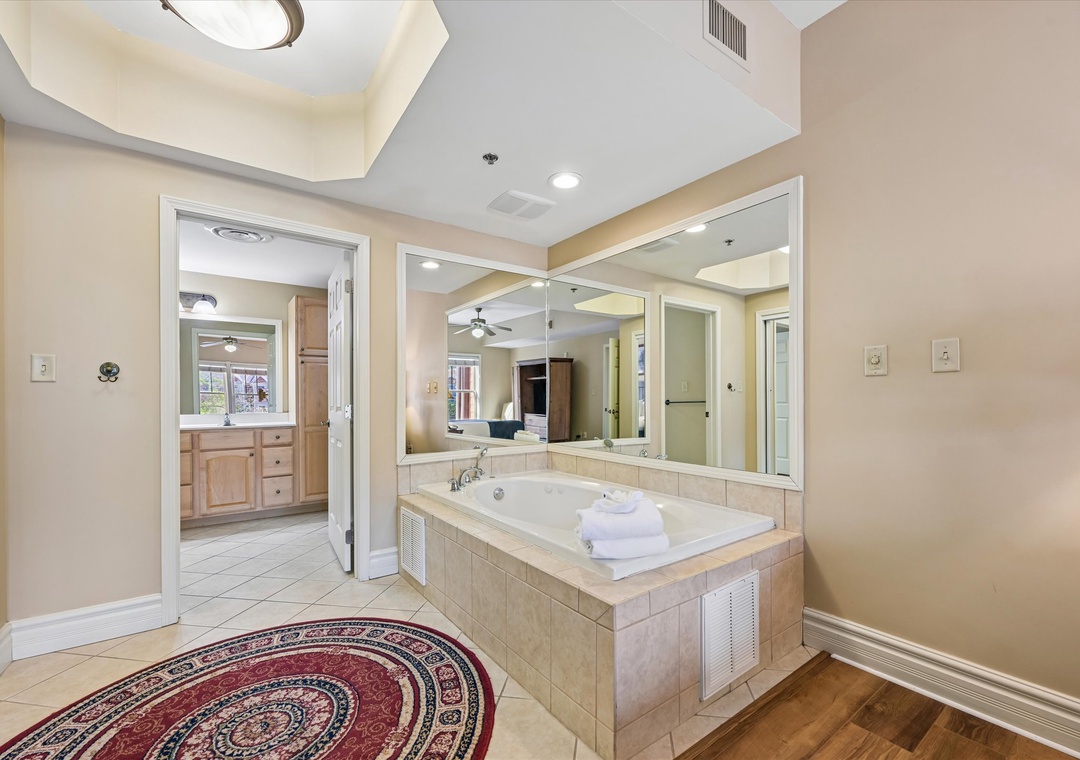 Sink into your private jetted tub surrounded by elegant marble and warm lighting for ultimate relaxation.