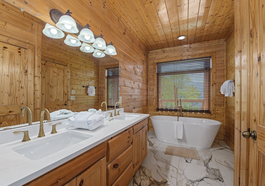 Soak your cares away in this luxurious rustic bathroom featuring a freestanding tub surrounded by warm cedar walls and elegant marble floors.