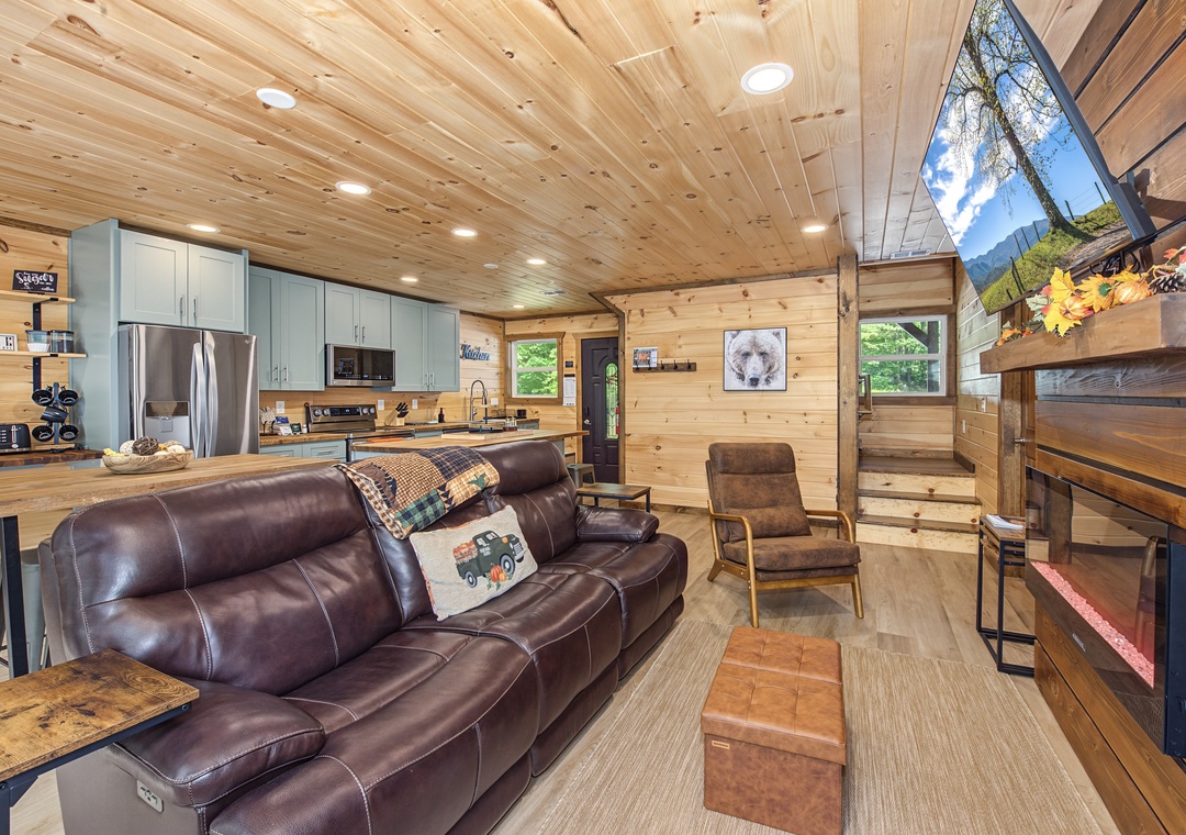 Relax in your cozy cabin retreat where warm wood walls meet modern comfort. Sink into the plush leather sofa, enjoy the fully-equipped kitchen, and take in mountain views through stunning A-frame windows.