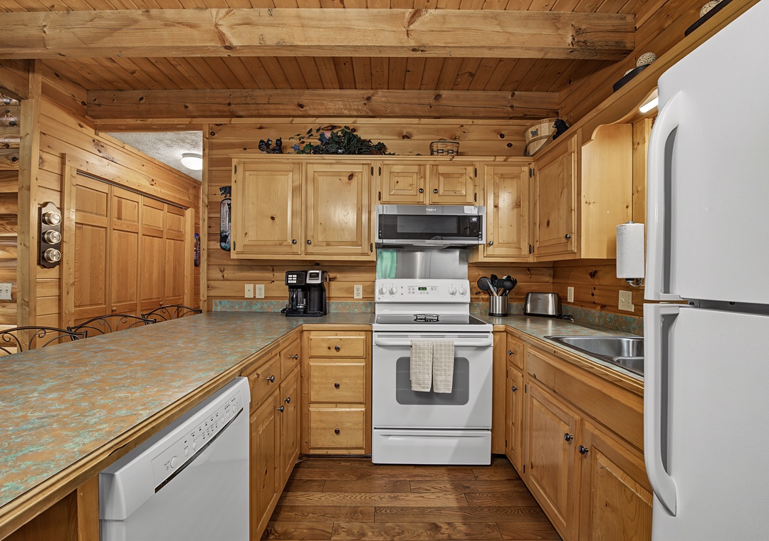 Your fully equipped kitchen features warm wood cabinetry, full-sized appliances, and everything you need to prepare meals during your stay in this cozy mountain retreat.