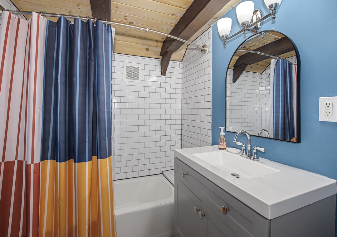 Freshen up in your modern bathroom featuring white subway tile, sleek fixtures, and a cheerful color palette that sets a relaxed, coastal vibe.