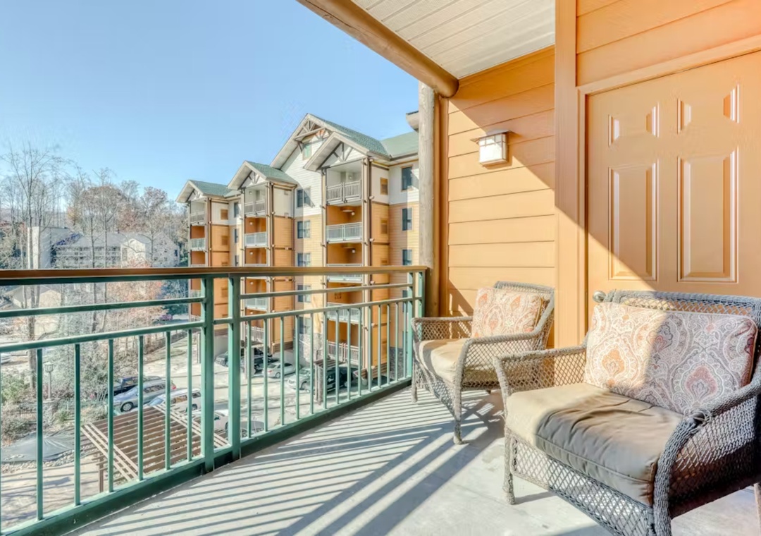 Unwind on your private balcony with comfortable wicker seating, watching the day unfold over the peaceful residential community below.