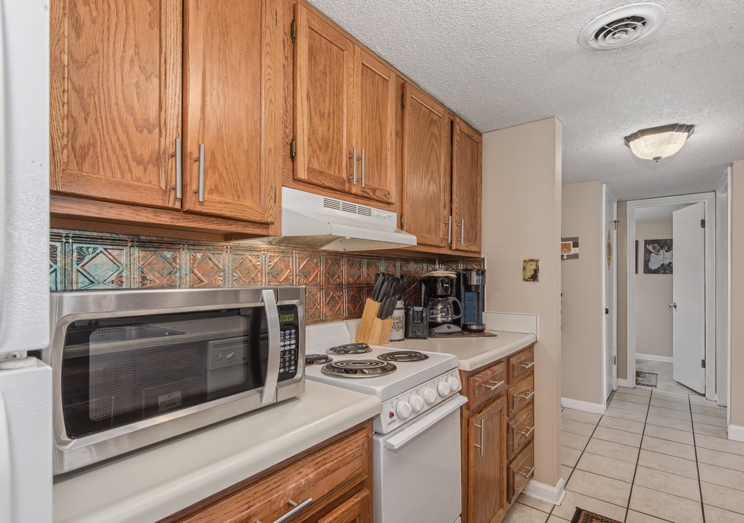 Cook your favorite meals in this fully equipped kitchen with warm wood cabinets, modern appliances, and everything you need for a comfortable stay.