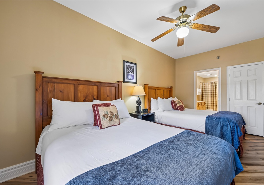 Rest peacefully in your cozy bedroom featuring twin beds with crisp linens and rustic wood headboards.