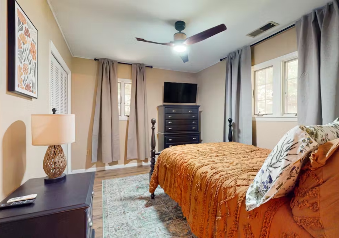 Drift off in your cozy bedroom featuring warm earth tones, a ceiling fan for comfort, and plenty of natural light.