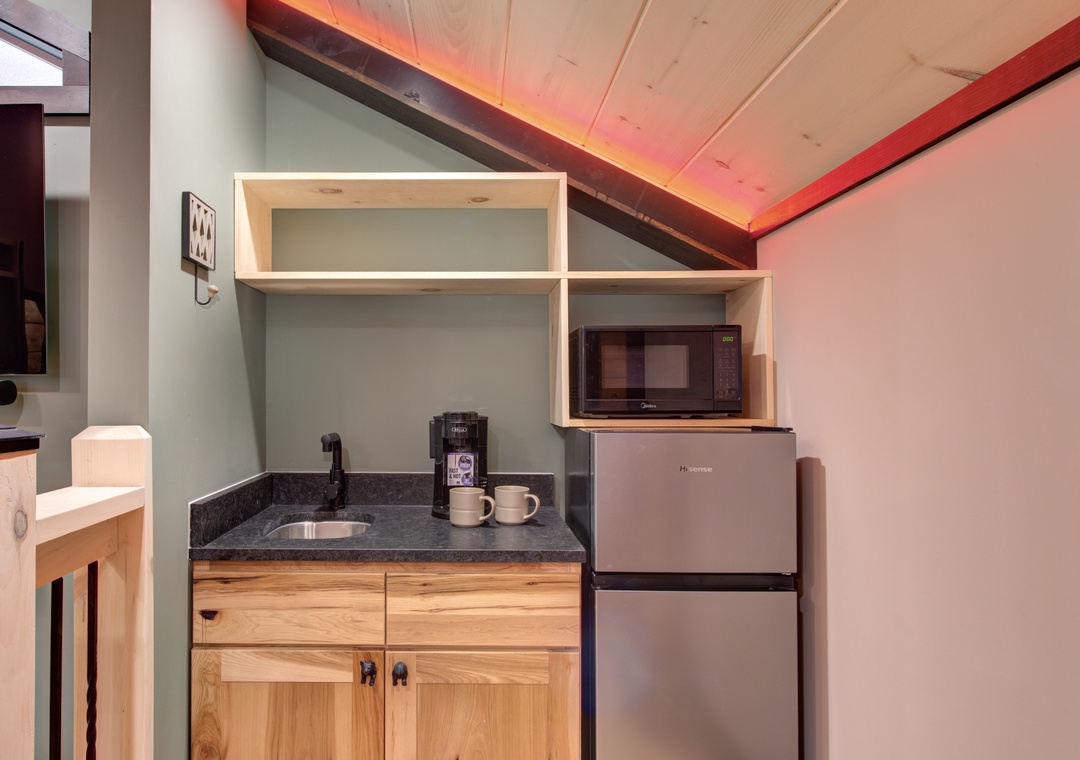 Your compact kitchenette features everything you need - microwave, mini-fridge, and coffee station perfectly arranged for cozy meal prep.