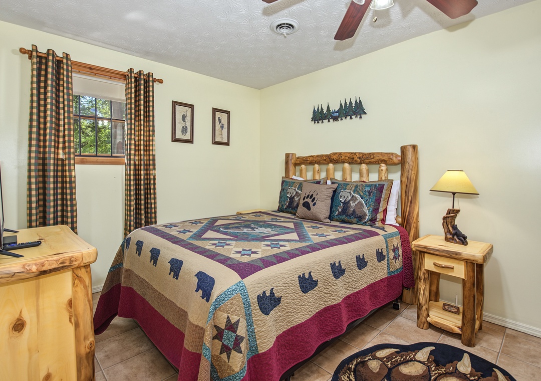 Your cozy bedroom features rustic log furniture and wilderness-inspired decor, with warm natural light streaming through the windows to welcome you after a day of adventure.